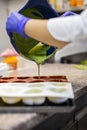 Woman confectioner pouring liquid chocolate into rubber mold tray for cooking pastry candy Royalty Free Stock Photo