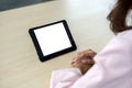 A woman confidently immersed in the virtual realm on tablet computer, seated at a contemporary table. Discover the wonders of