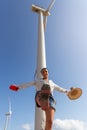 Renewable Energy Elegance: Woman Posing under a Towering Wind Turbine