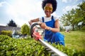 Trimming with Grace: A Woman's Artistry in Sculpting a Living Hedge