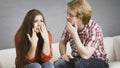 Woman confiding to man on sofa