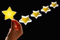A woman considers gives a first star rating, the concept of a positive rating, reviews and feedback on black Royalty Free Stock Photo