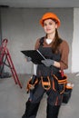 Woman construction contractor. Female Builder in hardhat and uniform holding clipboard looking at camera working in project of Royalty Free Stock Photo
