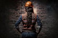 woman construction worker in front of brick wall, concept equality, generate by AI Royalty Free Stock Photo