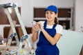 Female construction worker using smartphone in apartment Royalty Free Stock Photo