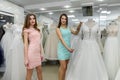 Woman consultant helping bride in choosing bridal gown