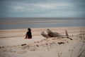 Woman contemplating on sandy beach while looking at the sea - spiritual concept of self-knowledge