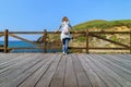 Woman contemplating the sea from an outdoor wooden balcony. Santander