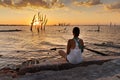 Woman contemplating the sunset in front of the sea