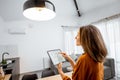 Woman controlling light with a digital tablet at home Royalty Free Stock Photo