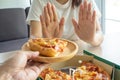 Woman controls the food, using her hands to push the pizza dish