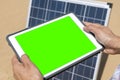 woman controls her solar panel via electronic tablet with green screen, green energy concept