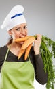 Woman cook biting carrots Royalty Free Stock Photo