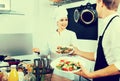 Woman cook giving to waitress ready to serve salad Royalty Free Stock Photo