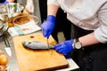 Woman cook preparing and cleaning raw dorada fish Royalty Free Stock Photo