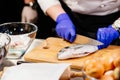 Woman cook preparing and cleaning raw dorada fish Royalty Free Stock Photo