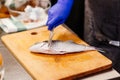 Woman cook preparing and cleaning raw dorada fish Royalty Free Stock Photo