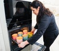 a woman cook puts in the oven dough in paper molds for baking Easter cakes.