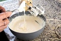 Woman cook putting ingredient into cheesecake preparation container