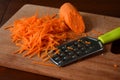 Woman cook sauerkraut or cabbage salad on wooden background. Step 2 - Grated carrots. Fermented preserved vegetables food concept