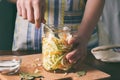 Woman cook sauerkraut or salad on wooden background. Step 5 - Put the cabbage in the jars. Fermented preserved vegetables food Royalty Free Stock Photo