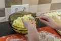 Woman cook sculpts dumplings from flour dough with potatoes