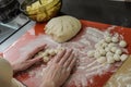 Woman cook sculpts round balls of dough from flour