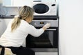 Woman cook sets the right temperature in the oven for baking Royalty Free Stock Photo