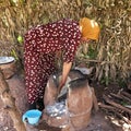 Woman cooking bread in an ancient oven in an outdoor shelter in front of her home in a Berber village in Morocco. Royalty Free Stock Photo