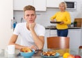 Woman cooking breakfast to her adult son Royalty Free Stock Photo