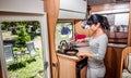 Woman cooking in camper, motorhome interior Royalty Free Stock Photo