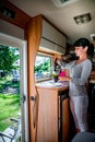 Woman cooking in camper, motorhome interior RV