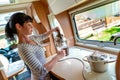 Woman cooking in camper, motorhome interior Royalty Free Stock Photo