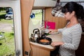 Woman cooking in camper, motorhome RV interior Royalty Free Stock Photo