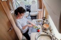 Woman cooking in camper, motorhome interior Royalty Free Stock Photo