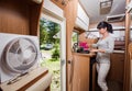 Woman cooking in camper, motorhome RV interior