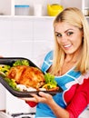 Woman cooking chicken at kitchen.