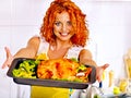 Woman cooking chicken at kitchen.