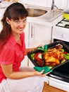 Woman cooking chicken at kitchen. Royalty Free Stock Photo
