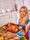 Woman cooking chicken at kitchen. Royalty Free Stock Photo