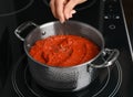 Woman cooking delicious tomato sauce in pan on stove