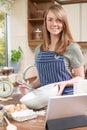 Woman Cooking And Following Recipe On Digital Tablet