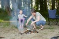 Woman cooking food, people camping in forest, family active in nature, kindle fire, summer season Royalty Free Stock Photo