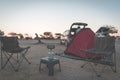 Woman cooking with gas stove in camping site at dusk. Gas burner, pot and smoke from boiling water, tent in the background. Advent Royalty Free Stock Photo