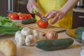 Woman cooking healthy meal in the kitchen. Cooking healthy food at home. Woman in kitchen preparing vegetables. Chef cuts the Royalty Free Stock Photo