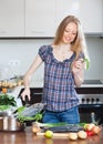 Woman cooking lubina fish in fryingpan Royalty Free Stock Photo