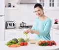 Woman cooking in new kitchen making healthy food with vegetables.