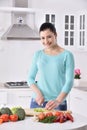 Woman cooking in new kitchen making healthy food with vegetables.