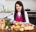Woman cooking potatoes with meat