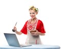 Woman is cooking with the recipe on a laptop